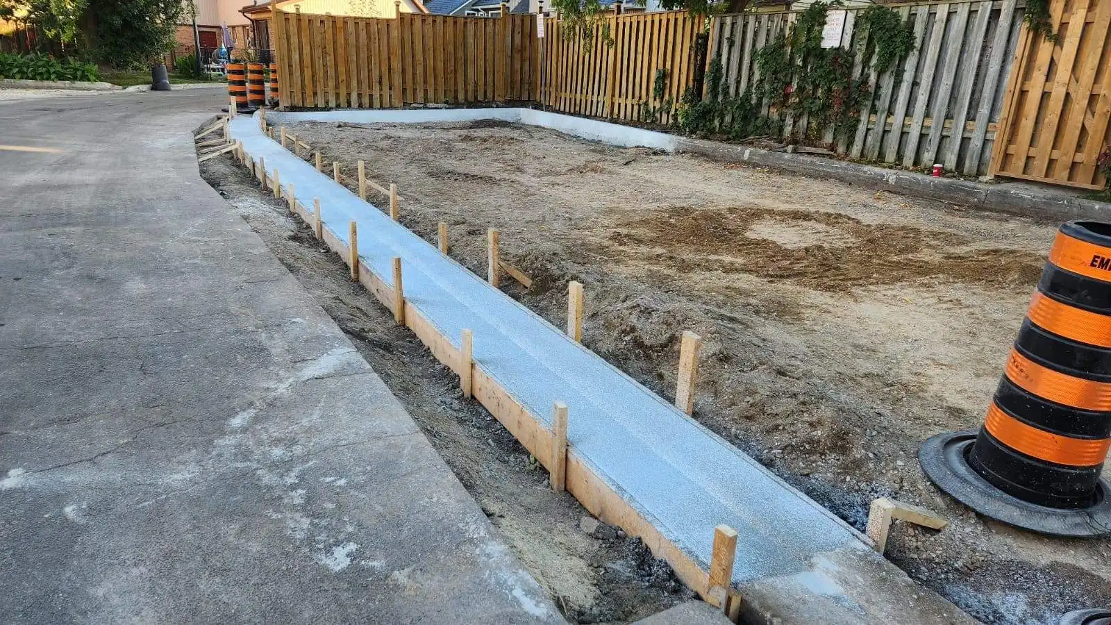 Freshly poured concrete sidewalk and curb installation by Empire Paving at a residential project site in Pickering, Ontario.