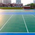 Freshly resurfaced tennis and multi-sport courts with vibrant pavement markings near a school campus, showcasing durable athletic court paving designed for recreation, safety, and long-term performance in educational and community settings.