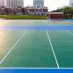 Freshly resurfaced tennis and multi-sport courts with vibrant pavement markings near a school campus, showcasing durable athletic court paving designed for recreation, safety, and long-term performance in educational and community settings.